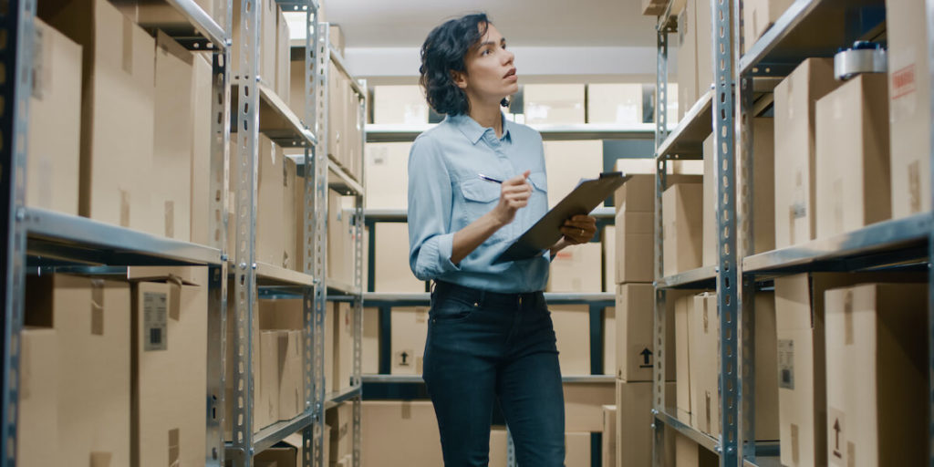 Woman with clipboard in warehouse